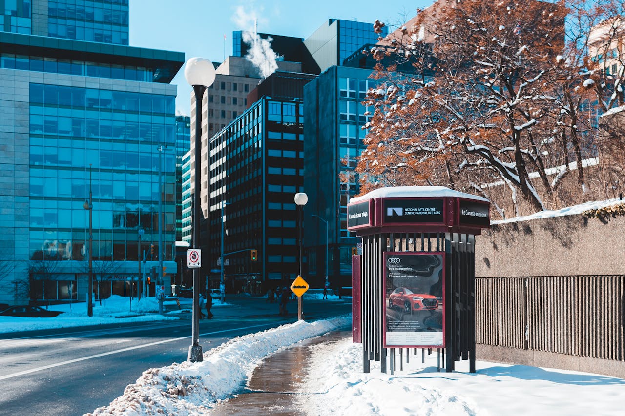 Snow-covered street showcasing modern architecture under a clear blue sky.